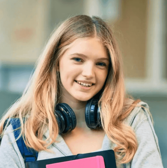 Smiling girl with headphones and books